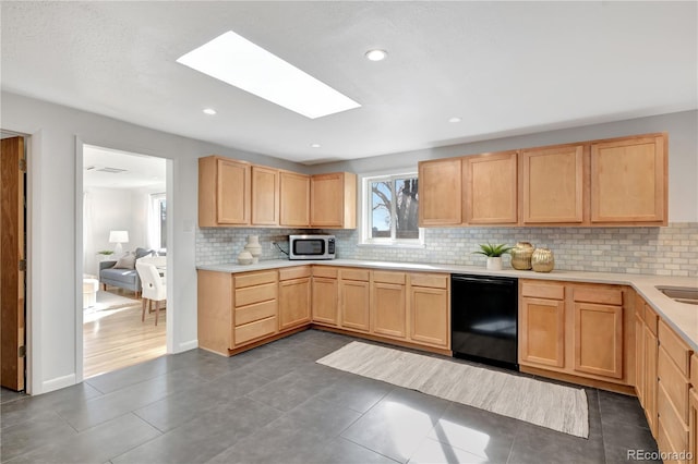 kitchen with black dishwasher, light countertops, and light brown cabinets