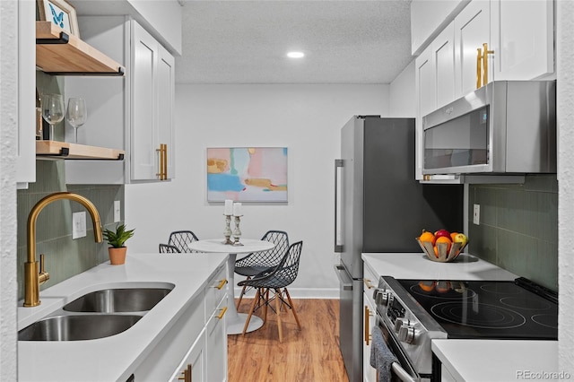 7615 E Quincy Ave Unit 103, Denver, CO 80237 - kitchen featuring stainless steel appliances, decorative backsplash, light countertops, white cabinets, and recessed lighting