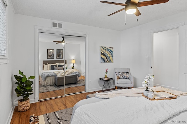 7615 E Quincy Ave Unit 103, Denver, CO 80237 - bedroom with a closet, wood finished floors, ceiling fan, and a textured ceiling