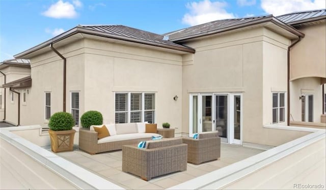 back of house with a patio area, stucco siding, metal roof, outdoor lounge area, and a standing seam roof