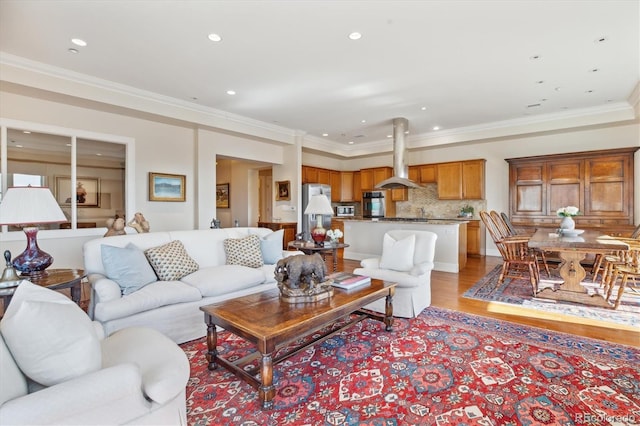 living room with ornamental molding, recessed lighting, and light wood-style floors