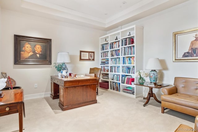 carpeted home office featuring baseboards and a raised ceiling