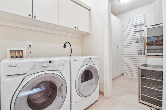 laundry room with cabinet space, washer and clothes dryer, and light tile patterned floors