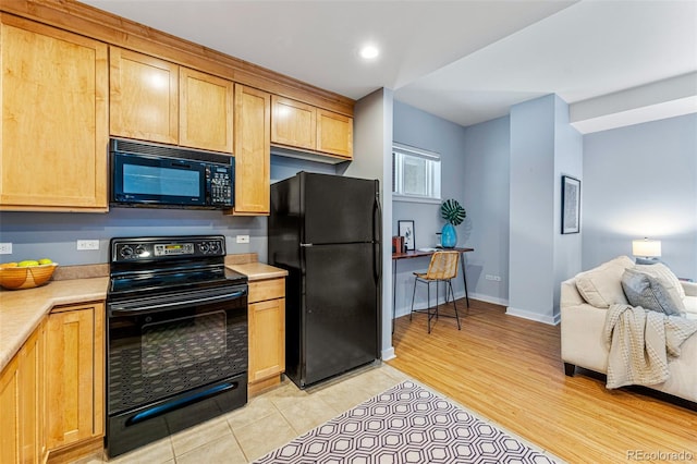 kitchen featuring light hardwood / wood-style floors and black appliances