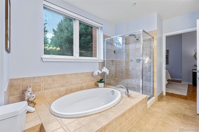 bathroom with tile patterned floors, toilet, and independent shower and bath