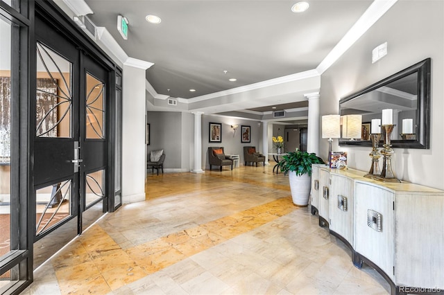 foyer entrance featuring decorative columns, crown molding, and a tray ceiling