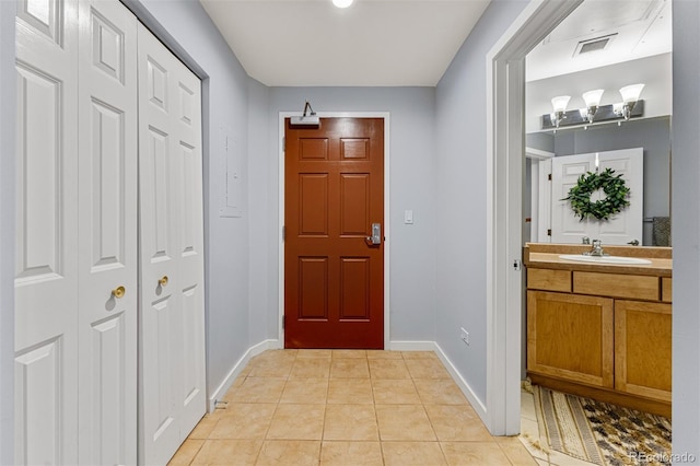 doorway with sink and light tile patterned floors