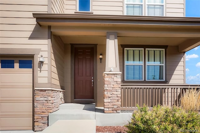 doorway to property with a porch and a garage