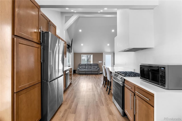 kitchen with light hardwood / wood-style flooring, wall chimney exhaust hood, stainless steel appliances, and lofted ceiling