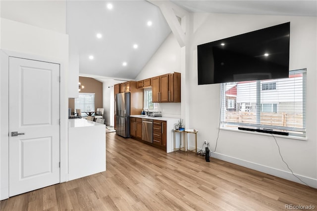 kitchen featuring a notable chandelier, high vaulted ceiling, light wood-type flooring, and appliances with stainless steel finishes