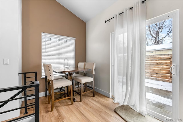 sitting room featuring a wealth of natural light, vaulted ceiling, and light wood-type flooring