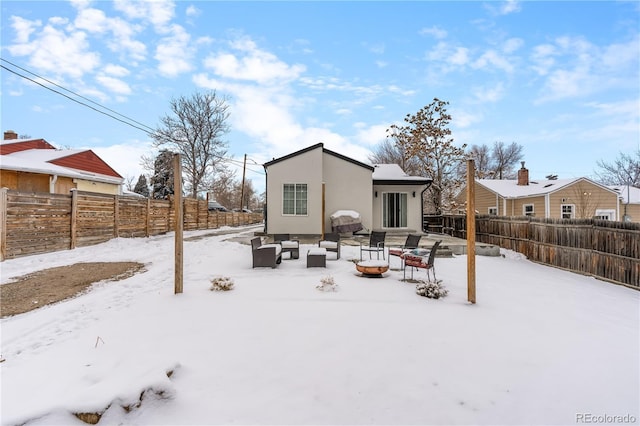 snow covered house featuring an outdoor living space with a fire pit