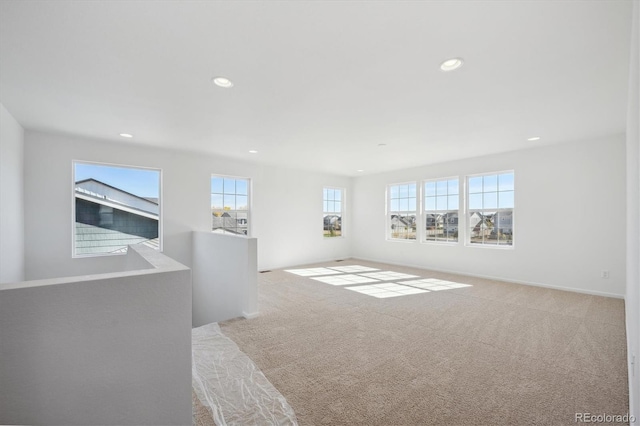 empty room featuring light colored carpet and plenty of natural light