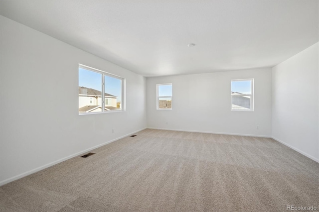 spare room featuring light colored carpet