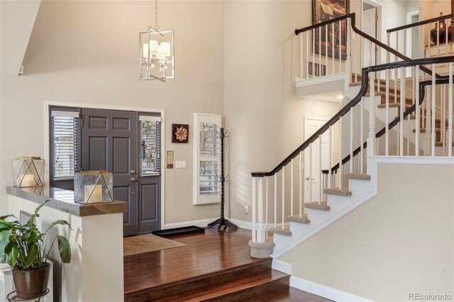 7836 S Fairfax Ct, Centennial, CO 80122 - entryway featuring a towering ceiling, wood finished floors, baseboards, stairway, and a chandelier