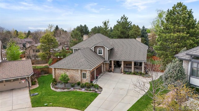 7836 S Fairfax Ct, Centennial, CO 80122 - view of front of property with an attached garage, a front lawn, a chimney, concrete driveway, and covered porch