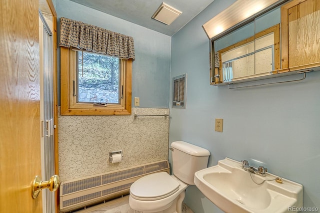 bathroom featuring toilet, decorative backsplash, radiator, and sink