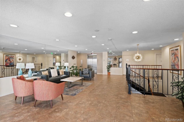 living room with a textured ceiling and a notable chandelier