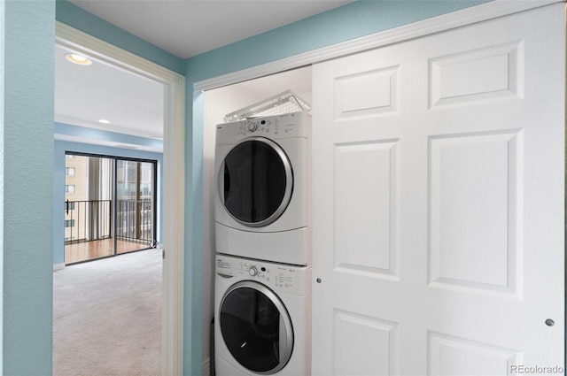 washroom with stacked washer and dryer and carpet floors