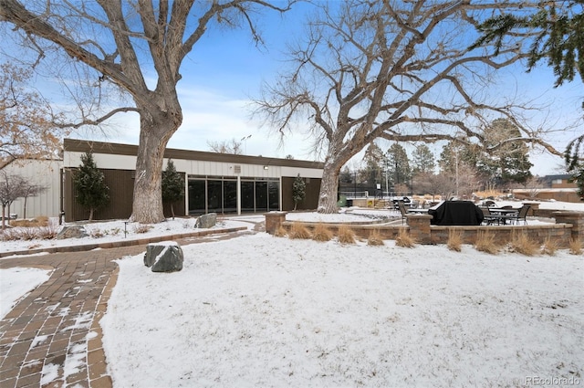 view of snow covered back of property