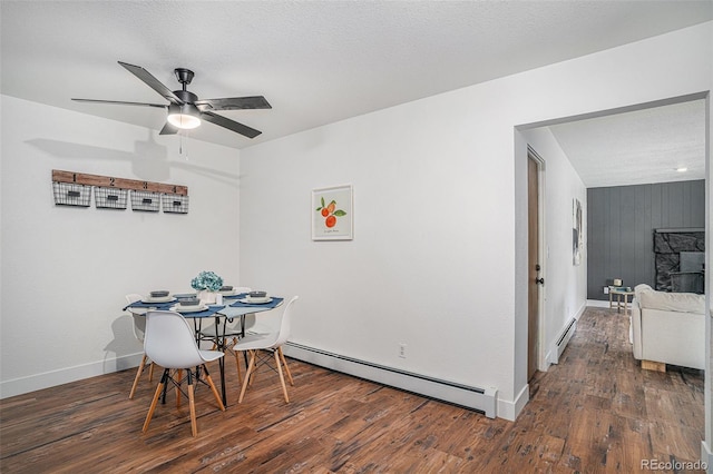 dining room featuring a baseboard heating unit, dark wood-type flooring, and baseboards