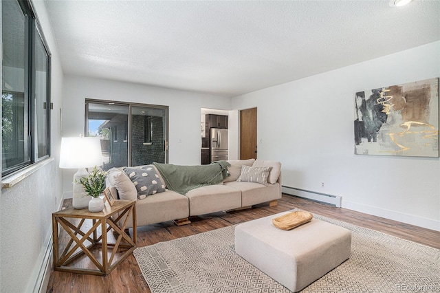 living room with a textured ceiling, baseboards, baseboard heating, and dark wood-style flooring