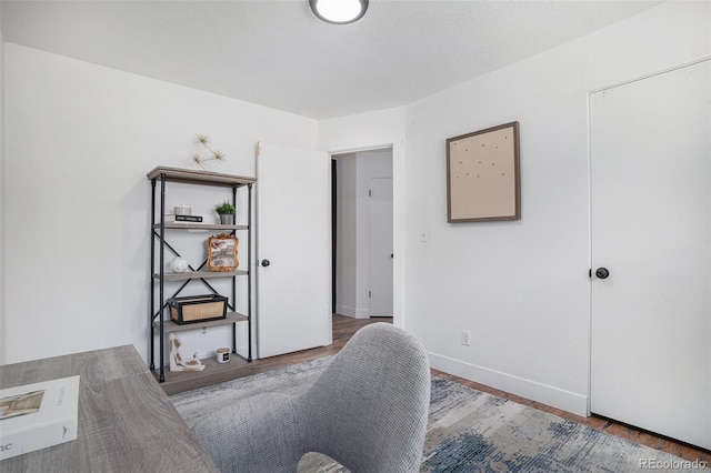 office area with baseboards and wood finished floors