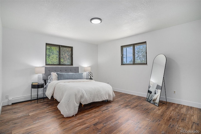 bedroom with dark wood-style floors, a textured ceiling, a baseboard radiator, and baseboards