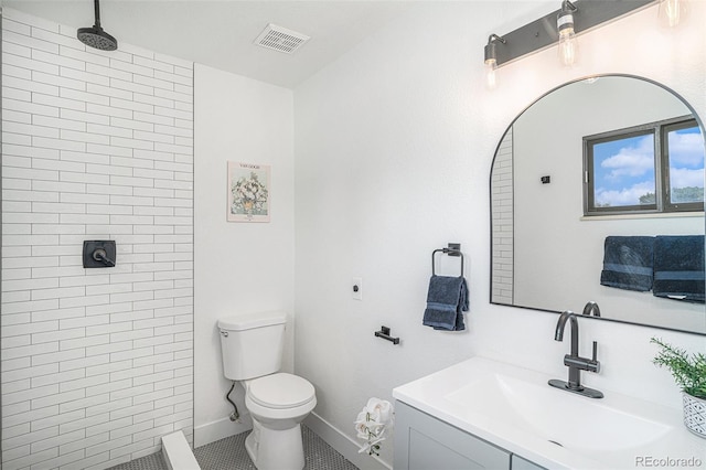 full bathroom featuring toilet, tiled shower, vanity, and visible vents