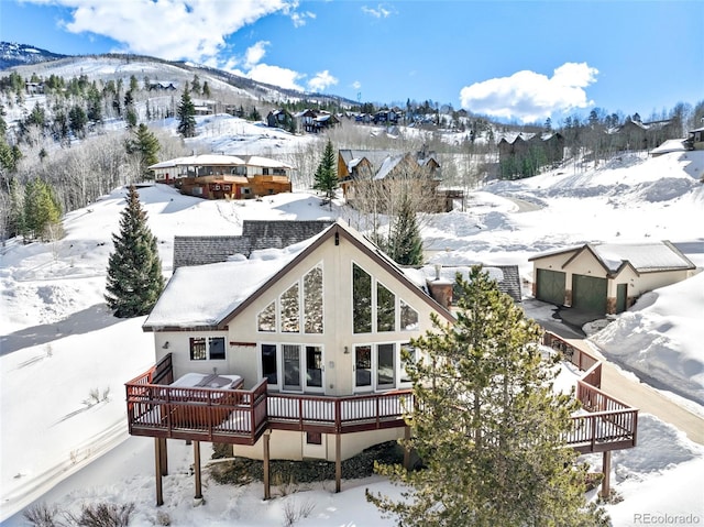 snow covered house featuring a deck