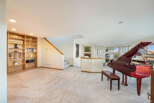 sitting room with stairs, carpet flooring, visible vents, and built in shelves