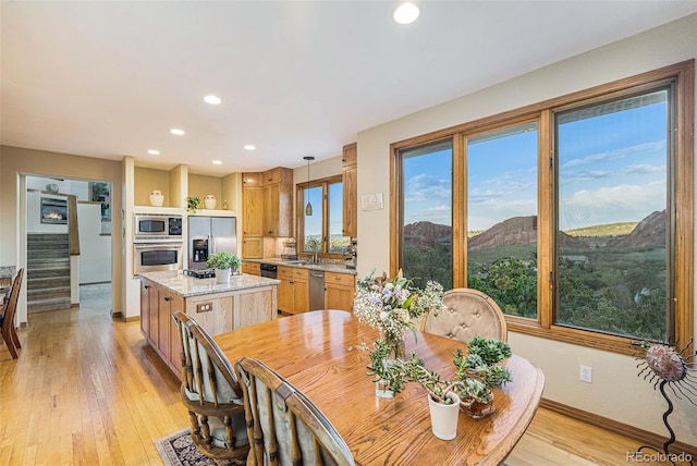 dining space featuring a mountain view, light wood-type flooring, recessed lighting, stairway, and baseboards
