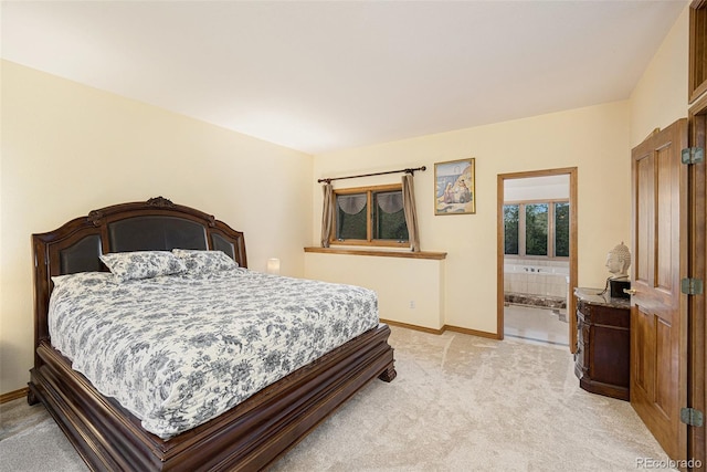 bedroom with light colored carpet, ensuite bathroom, and baseboards