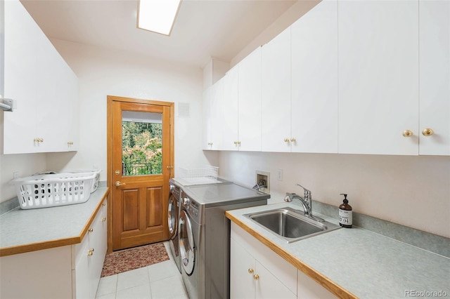 washroom with a sink, washer and clothes dryer, cabinet space, light tile patterned flooring, and visible vents