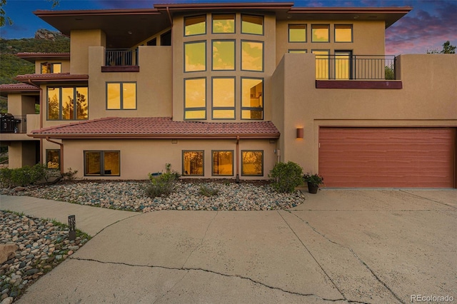 back of house with a balcony and stucco siding