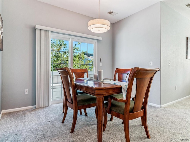 dining space featuring light carpet