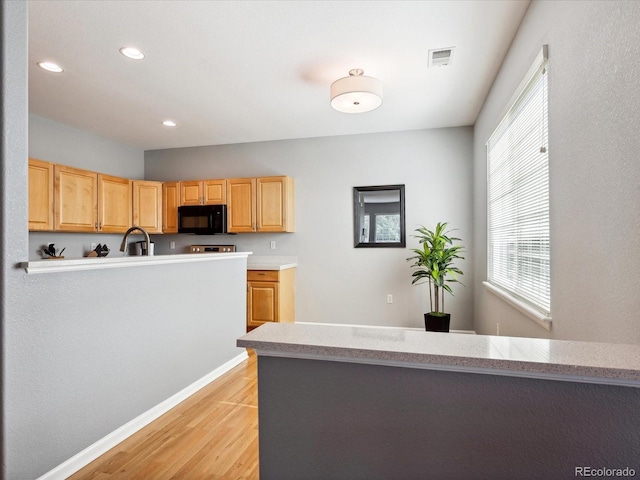 kitchen featuring light brown cabinets and light hardwood / wood-style floors