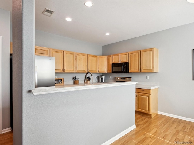 kitchen featuring light wood-type flooring, light brown cabinetry, sink, stainless steel appliances, and kitchen peninsula