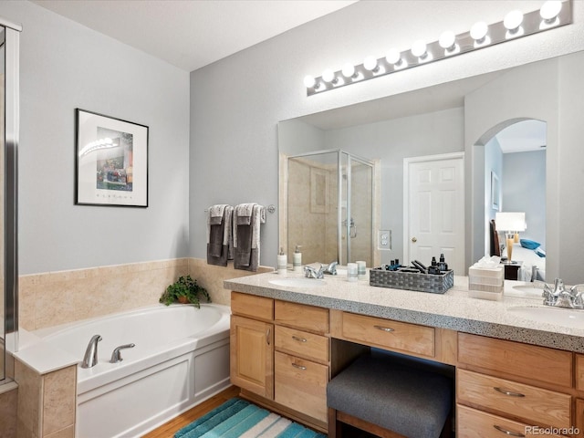 bathroom featuring independent shower and bath, vanity, and wood-type flooring