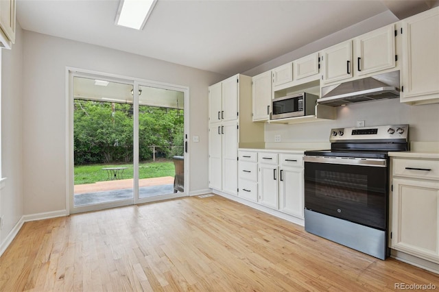2709 S Franklin St, Denver, CO 80210 - kitchen with stainless steel appliances, under cabinet range hood, light wood-type flooring, light countertops, and white cabinetry