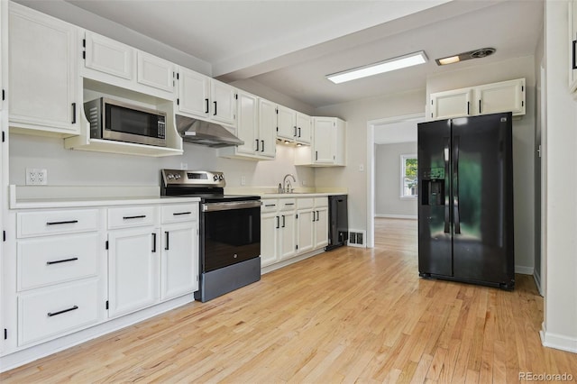 2709 S Franklin St, Denver, CO 80210 - kitchen with appliances with stainless steel finishes, under cabinet range hood, light wood-style flooring, and light countertops