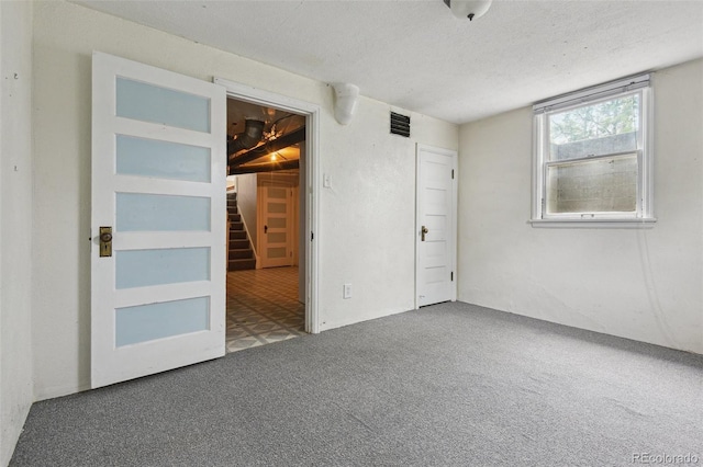 2709 S Franklin St, Denver, CO 80210 - spare room featuring carpet, stairs, and a textured ceiling