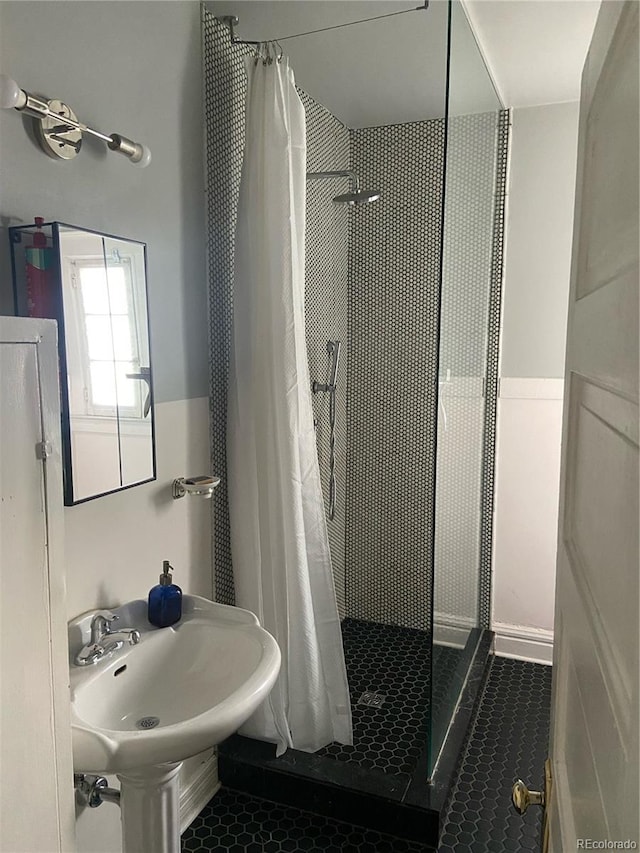 bathroom featuring curtained shower, sink, and tile patterned floors