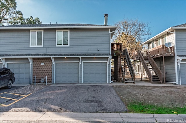 7945 York St Unit 2, Denver, CO 80229 - back of house featuring stairway, a garage, driveway, brick siding, and a deck