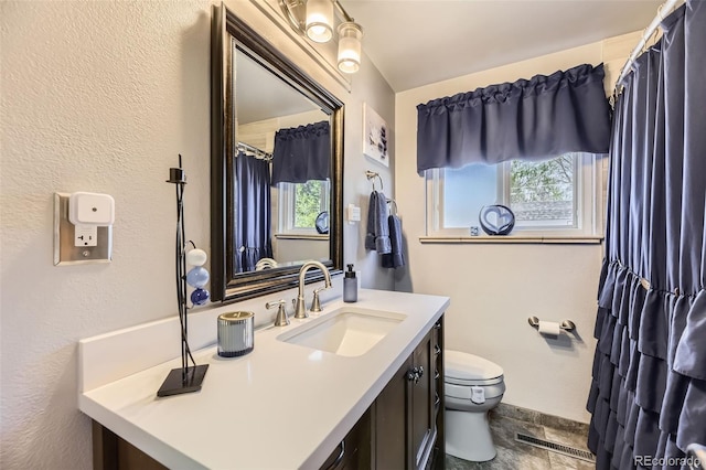 full bath featuring vanity, baseboards, visible vents, and toilet