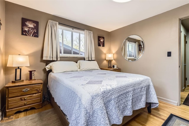 bedroom featuring baseboards and wood finished floors