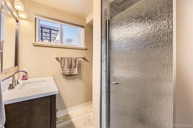 full bath featuring baseboards, a shower stall, and vanity