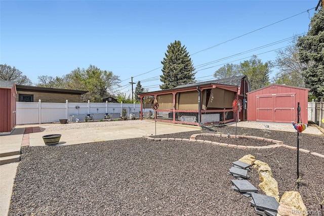 view of front of property featuring a patio, an outbuilding, a fenced backyard, and a storage unit