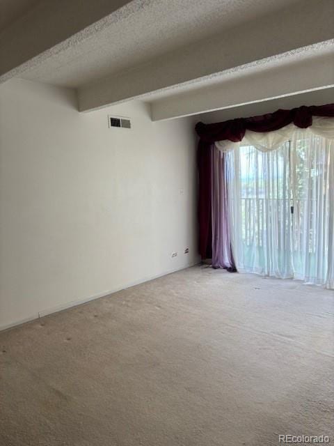 carpeted spare room featuring a textured ceiling