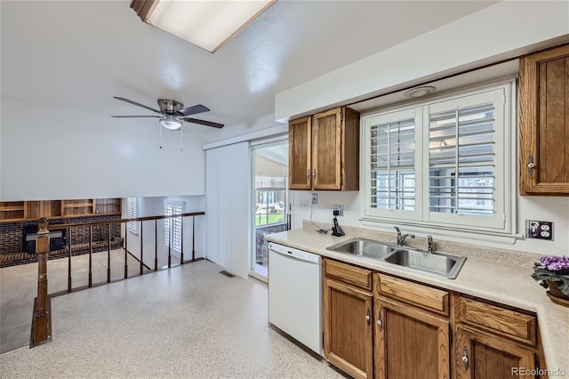 kitchen with white dishwasher, a sink, visible vents, light countertops, and brown cabinets